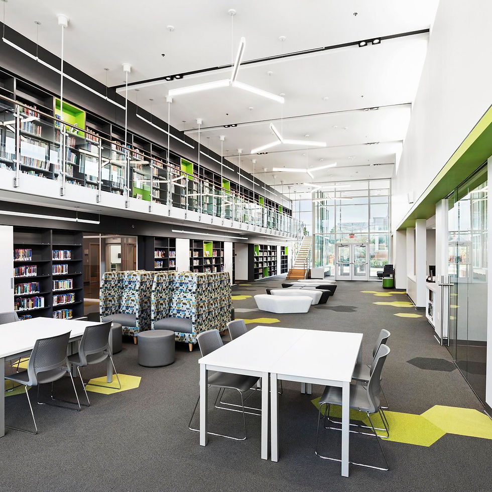 Modern library or learning center with bookshelves, diverse seating areas, and a staircase.