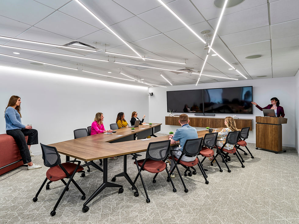 Conference room at COFCO, a Henricksen Company Philadelphia showroom, featuring a large wooden meeting table, ergonomic Allsteel chairs, glass walls, built-in display screen, and modern lighting for a polished professional setting.