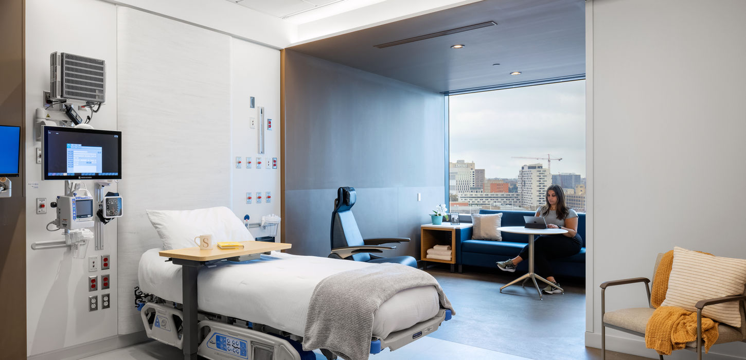 Modern hospital room with patient bed and city view