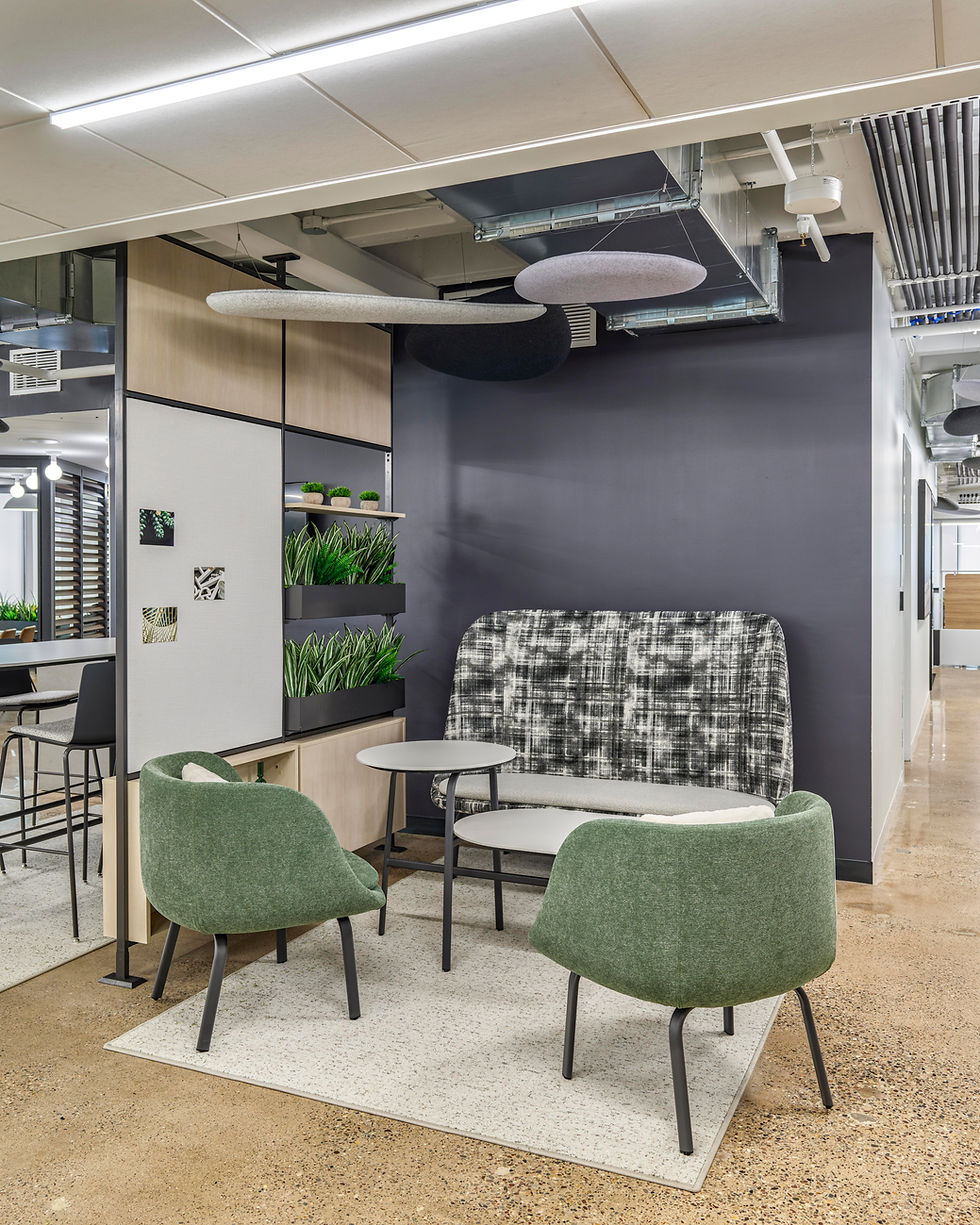 Modern open-office environment at COFCO, a Henricksen Company Philadelphia showroom, featuring collaborative workstations with red and wood finishes, lounge seating, glass-enclosed meeting rooms, and natural light highlighting the downtown skyline views